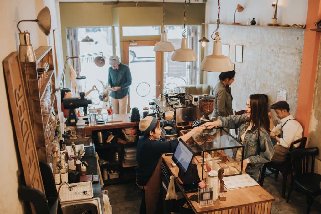 A café owner managing his busy venue from his phone